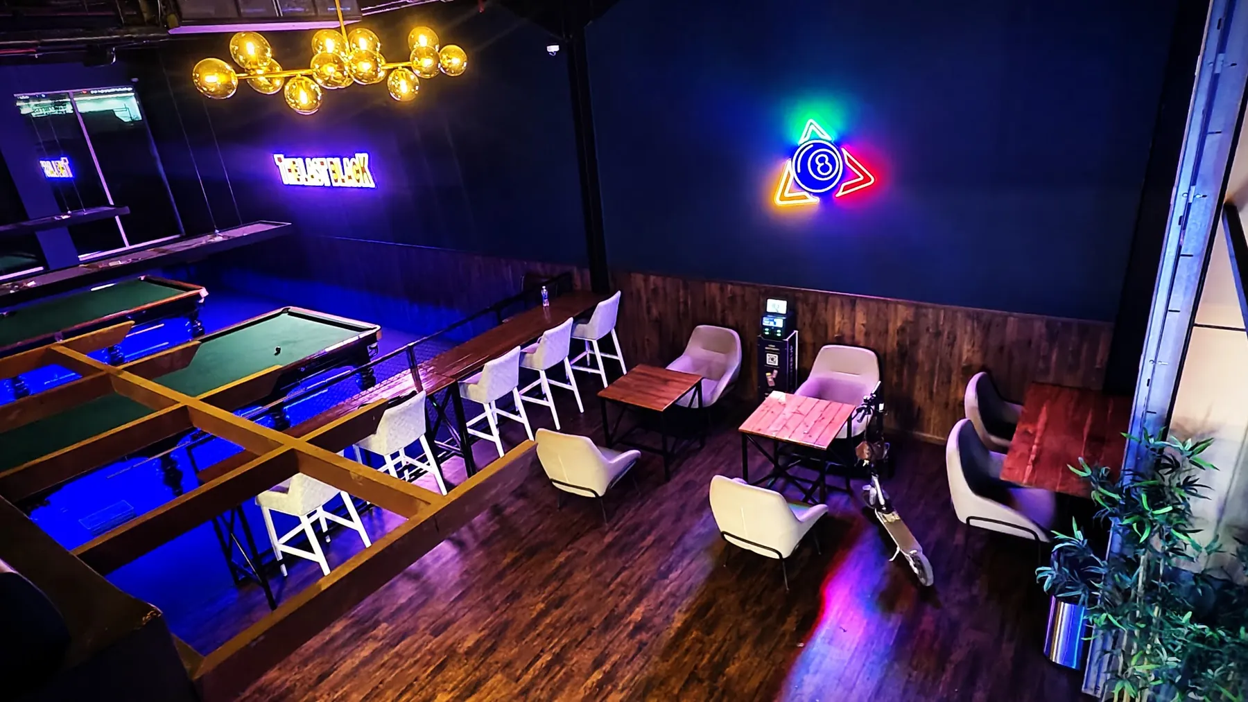 Lounge seating and bar stools under neon light at The Last Black, Al Qusais