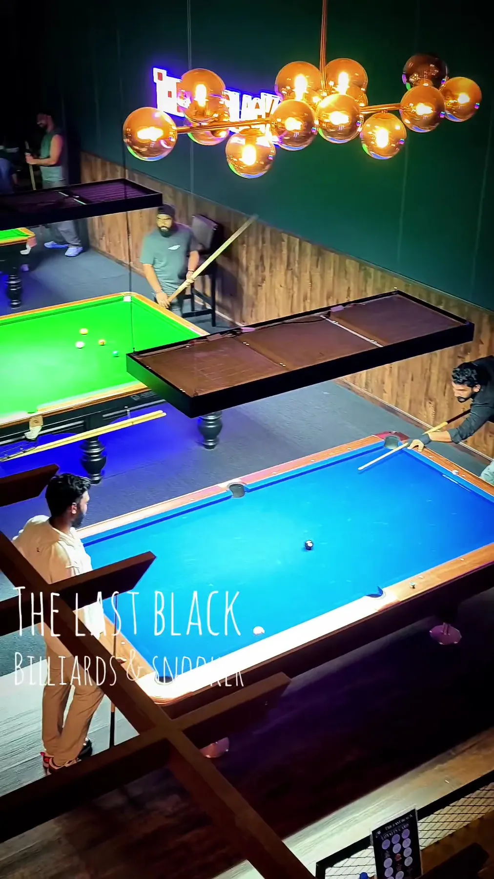Full-size snooker table under a long light